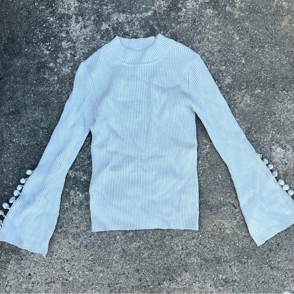 Sweater with pom pom fringe on sleeve